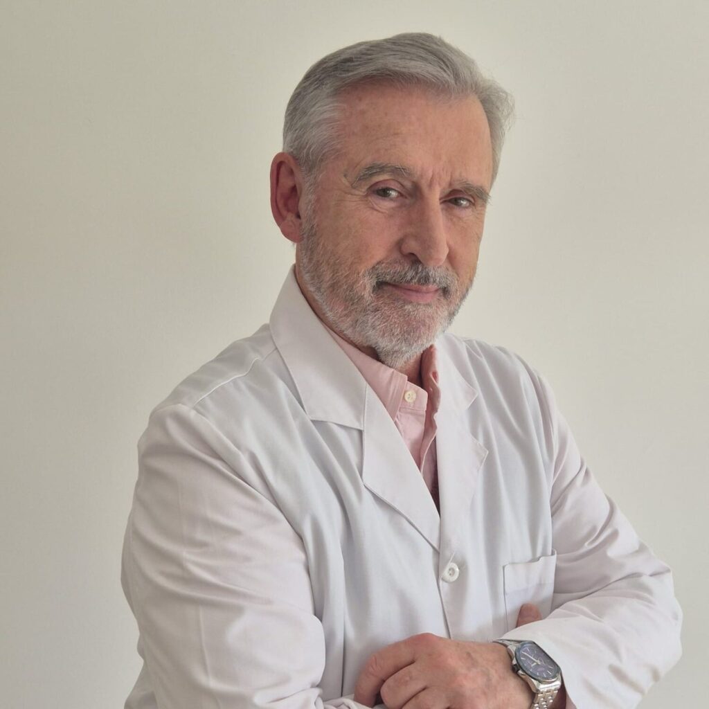El Dr. Ángel Rodríguez-Mata con bata blanca, retratado en su consulta de Madrid